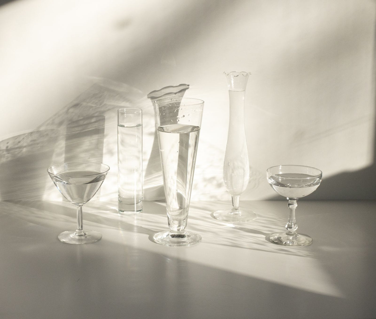 Assorted crystal glassware in warm sunlight